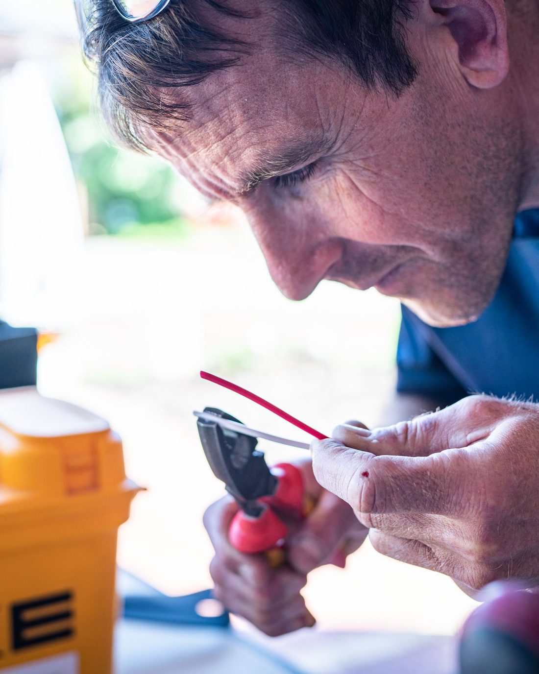 Franck Pluquet, électricien à Hyères, préparant un câble sur son établi