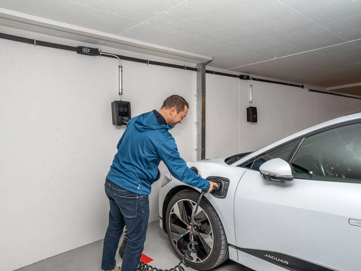 Voiture électrique en charge sur une borne installée dans un garage